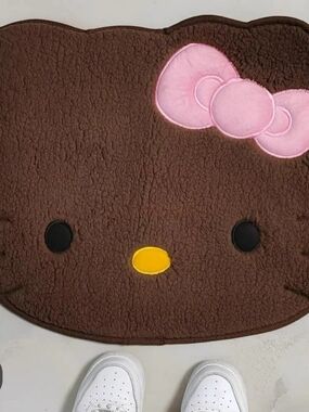Unk Brown Plush Character Rug with Pink Bow and Yellow Nose